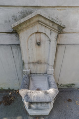 Old ancient gray Well on Stone Wall. Roman stone wall fountain