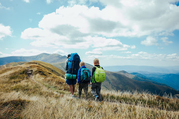 Fototapeta premium Family, dad and children go camping in the mountains