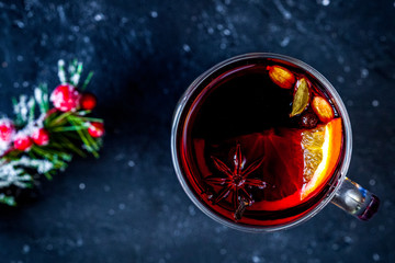 Christmas mulled wine with spices in cup on dark background