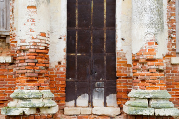 blocked entrance to an abandoned antique building with crumbling walls © Вячеслав Думчев