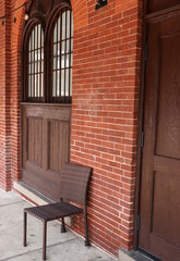 Fototapeta na wymiar Single Chair Outside Elegant Brick Building