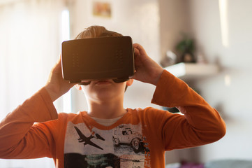 boy playes with modern virtual reality glasses