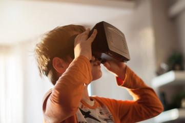 boy playes with modern virtual reality glasses