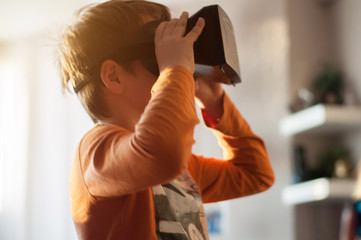 boy playes with modern virtual reality glasses