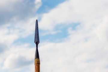 Naklejka premium Spear on sky background. Cold weapons. A symbol of war and protection_