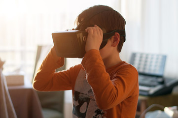 boy playes with modern virtual reality glasses