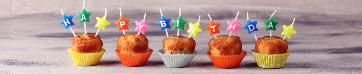 Chocolate muffin and nut muffin with happy birthday candle, homemade bakery on table