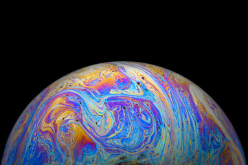 Abstract Soap bubble macro photo with black background look like planet