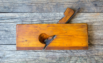 Vintage wood plane on a wooden plank background