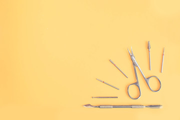 Top view of manicure and pedicure equipment on yellow background. Beauty, care and fashion concept....