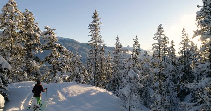Woman Snowshoeing In The Mountains At Sunset