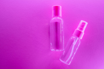 Cosmetic bottles with clear lotion in trendy bright neon light. The concept of cosmetics, skin care, beauty and health. Minimalism, place for text.