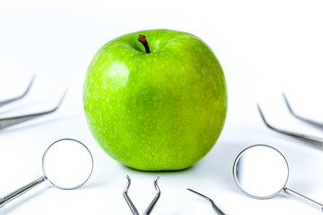 dental tools with apple on white background