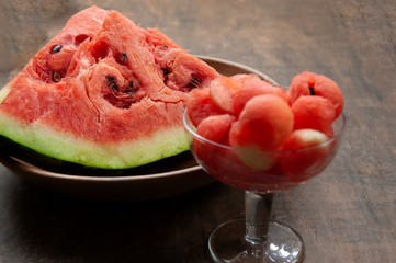 In the foreground, bowl with watermelon balls.In the dish watermelon pieces, with seeds.Abstract...