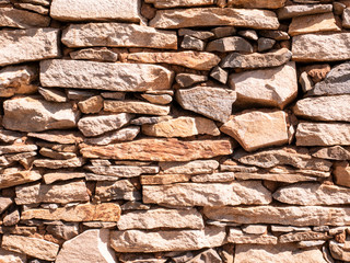 Old stone wall texture background natural color on the sunny day.