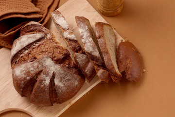 fresh rustic wholemeal rye bread, sliced on a wooden board,