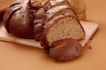 fresh rustic wholemeal rye bread, sliced on a wooden board,