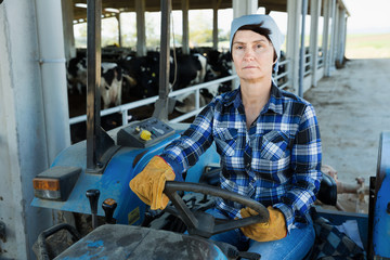 Fototapeta na wymiar Senior workwoman farmer sitting in tractor