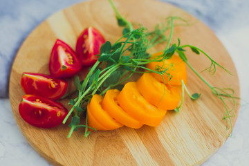 red and yellow sliced tomatoes with greenery. close-up