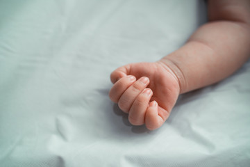 cropped image of little daughter hand when sleep on crib