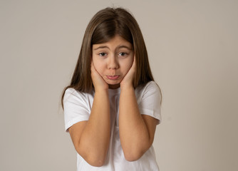 Young unhappy little girl making cute sad facial expression.