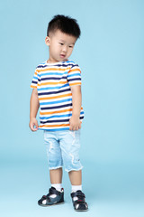 Beautiful boy in fashion clothing on blue background