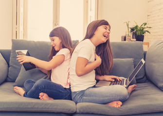 Obraz premium Two pretty sisters having fun together playing and surfing on th