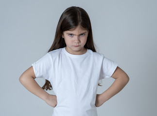 Pretty little girl with a angry facial expression looking mad at the camera. Children emotions