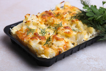 Baked cauliflower in plastic container