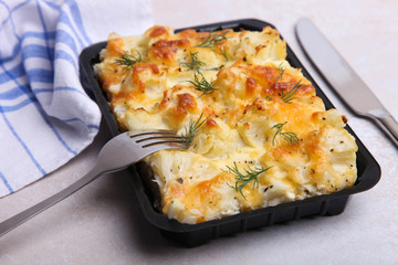 Baked cauliflower in plastic bowl