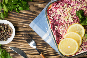 Herring under fur coat. Traditional Russian salad herring under a fur coat, vintage wood background.