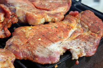Pork neck getting grilled on open fire