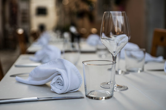 The interior of the summer restaurant. Tables are served with glassware for drinks and Cutlery. Concept: preparing the table for service. Selective focus. Copy space.