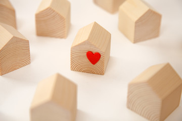Miniature wooden house with red heart among others wooden houses