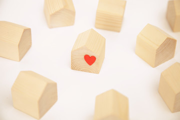 Miniature wooden house with red heart among others wooden houses