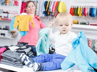 Portrait joyful boy with mother in kid store