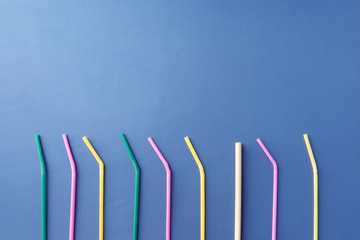 Plastic straws and one bamboo straw in a row