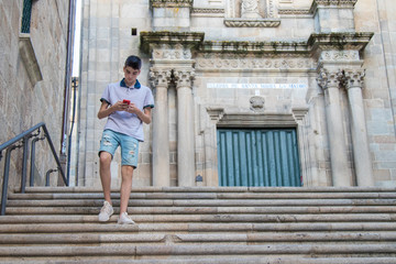 Fototapeta na wymiar young teenage man with mobile phone walking in the city