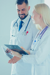 Two doctors holding a folder and talking about patient