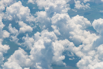 Naklejka na ściany i meble View from an airplane on the ground, clouds field and blue sky. Cloud wallpaper