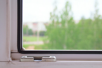 Fototapeta premium Double-glazed window and mosquito net. Close-up. View from the apartment to the street. Background. Texture.