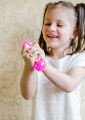 Child girl holding stress relief grape balls. squeezing balls, mesh squishy balls in kid's hands