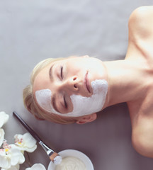 Face mask.Beautiful young girl at spa ,cosmetician woman applying facial mask.