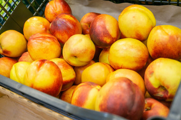 Peaches in drawers in a supermarket on a store counter for sale.