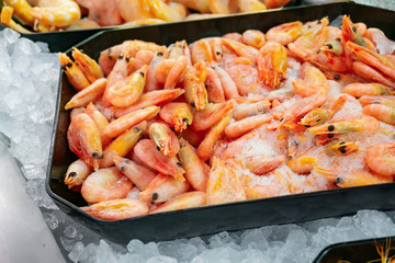 Shrimp on the counter of a shop window in a supermarket, seafood on sale.