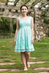 Fototapeta premium portrait of young woman in dress near roses in a garden