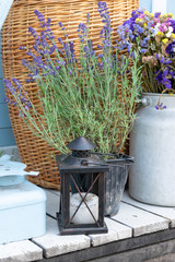 Vintage rustic candle lantern with lavander and dried flowers standing outsite on wooden porch