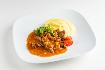 meat with mashed potato on the white plate