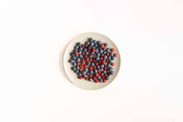 a plate with red berries and blackthorn