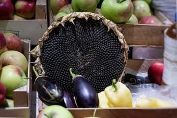Sunflower hat with seeds. Farmers market with vegetables and fruits, open shelves of shop windows. Healthy organic food